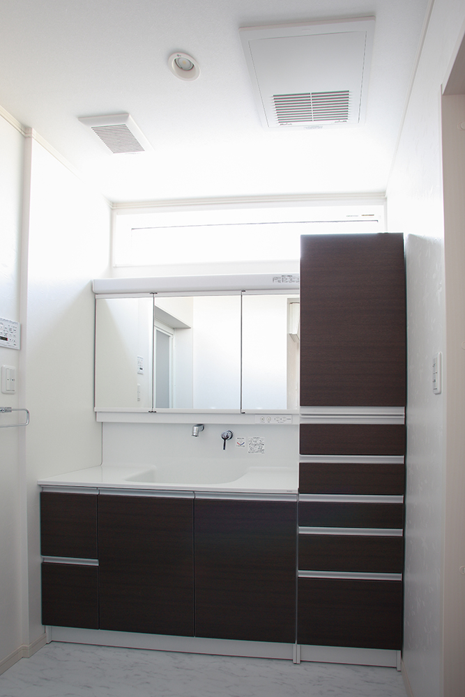 高窓からの採光で明るく、ゆったり とした開口の洗面室は清潔な印象。