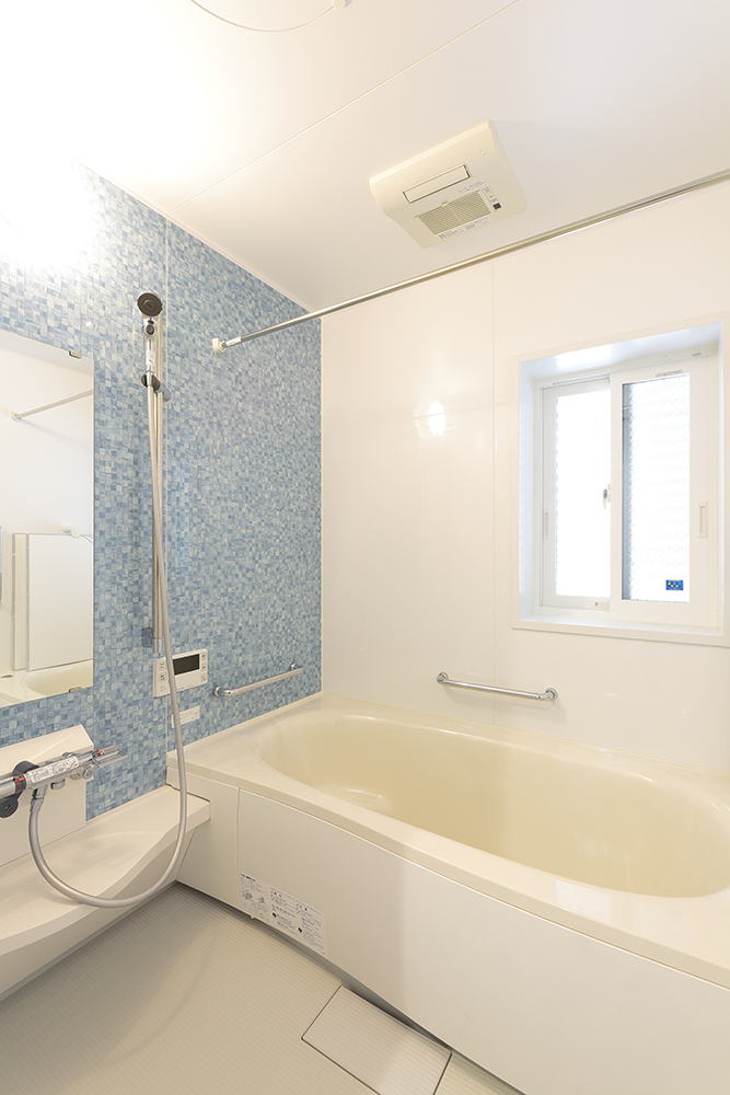 爽やかなブルーのパネルが印象的なバスルーム。 浴室換気乾燥暖房機を設置。 1